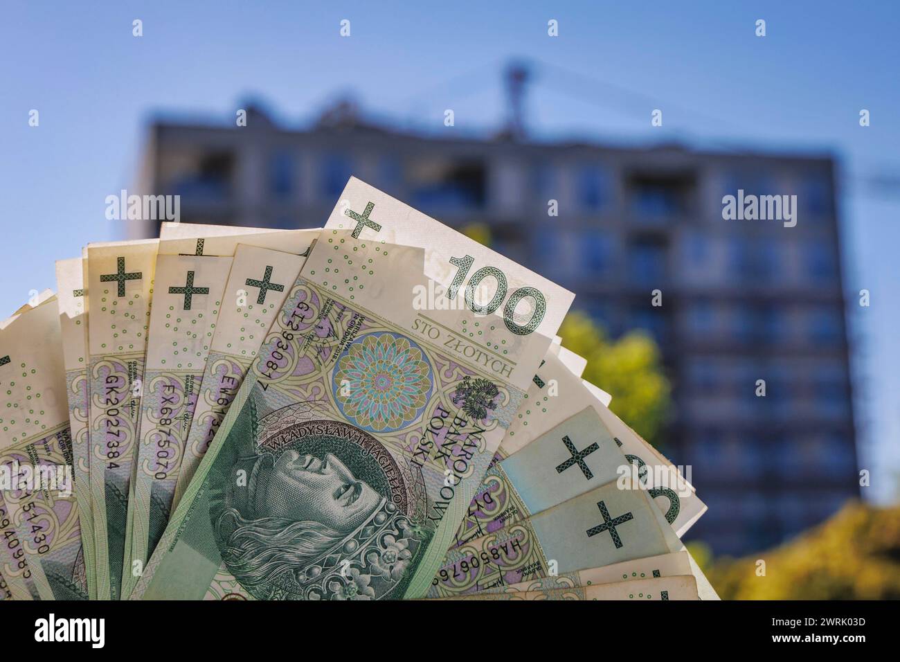 Banconote da 100 zloty polacchi contro il cantiere di un nuovo condominio a Varsavia, Polonia Foto Stock