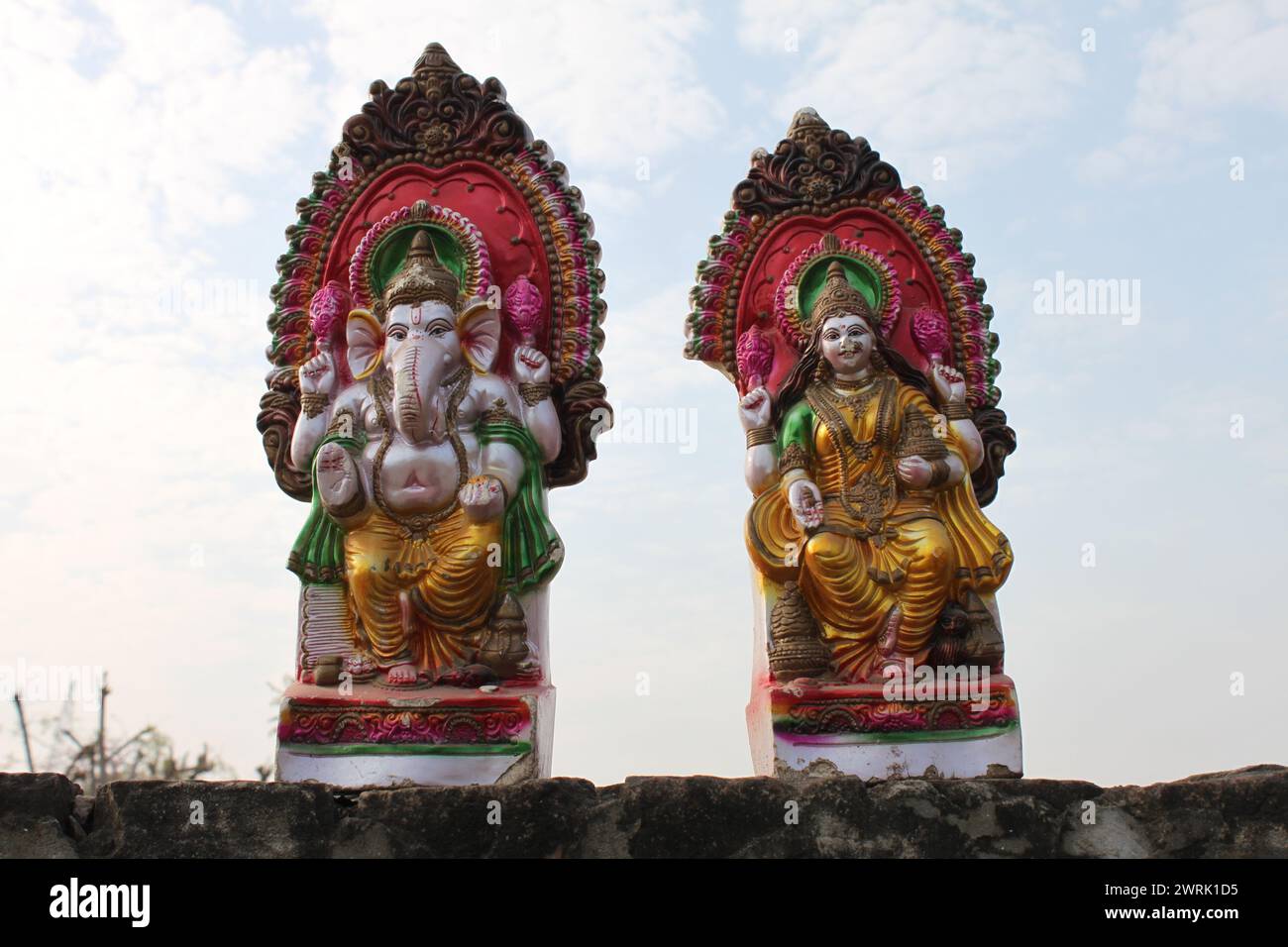 Agra, Uttar Pradesh, 11 marzo 2019: India- due colorate statue della divinità indù di Shiva e Ganesh in piedi su un muro ad Agra, in India, con il cielo nel bac Foto Stock