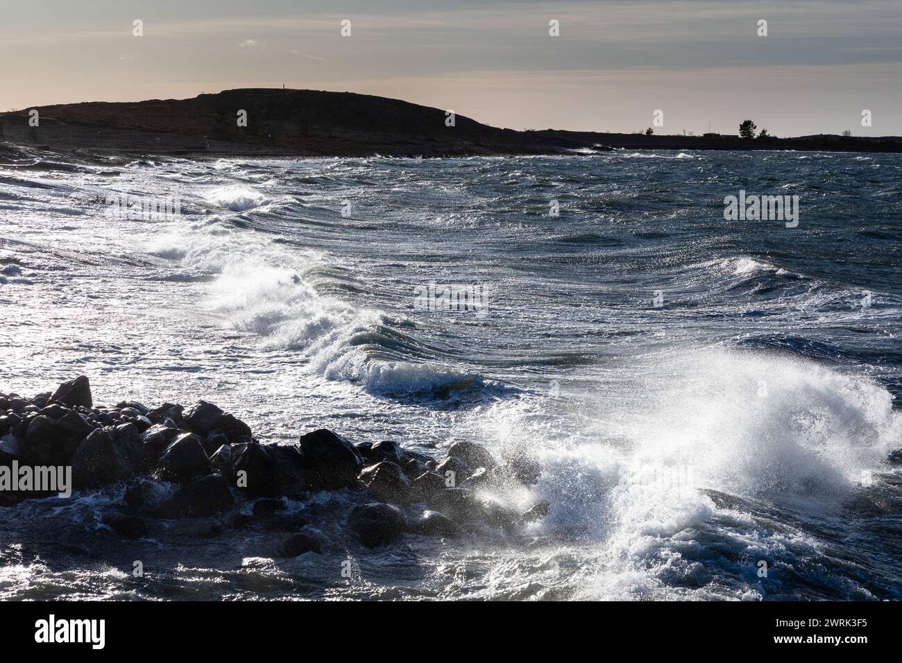 LE ONDE SI INFRANGONO SU Un BREAKWATER A JURMO, NEL MAR BALTICO: Le onde delle tempeste invernali si INFRANGONO lungo un frangiflutti nel piccolo porto locale di Jurmo, una piccola isola nell'arcipelago di Turku, al largo della costa sud-occidentale della Finlandia. Foto: Rob Watkins. INFORMAZIONI: Jurmo ha una popolazione di circa 50 persone ed è conosciuta per il suo terreno accidentato, i paesaggi pittoreschi e la flora e la fauna uniche. Jurmo è l'ultima parte fuori terra del sistema geologico di creste Salpausselkä dell'era glaciale, che attraversa la Finlandia. Foto Stock