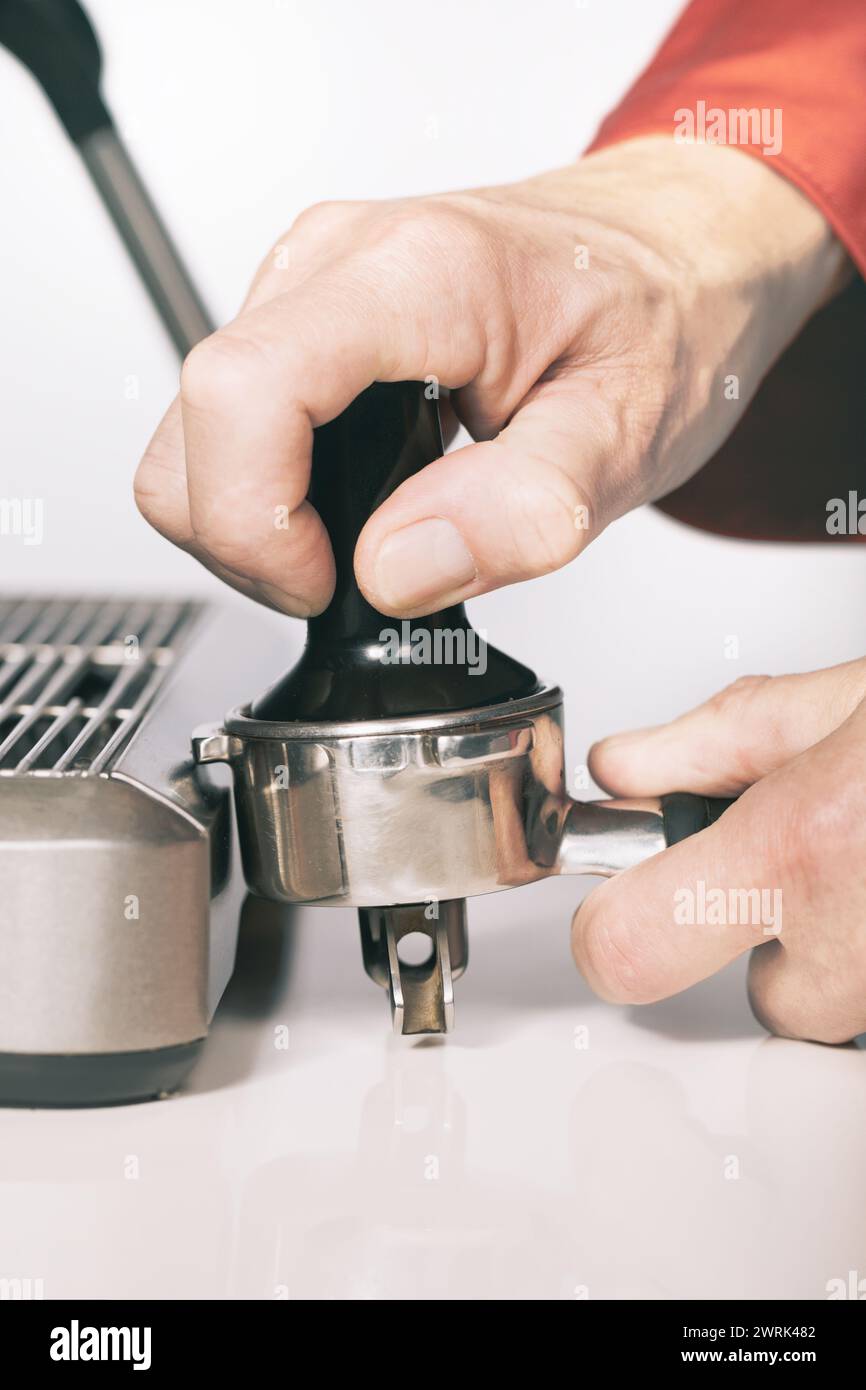 Premere il caffè macinato nell'impugnatura per estrarre il caffè nella macchina espresso Foto Stock