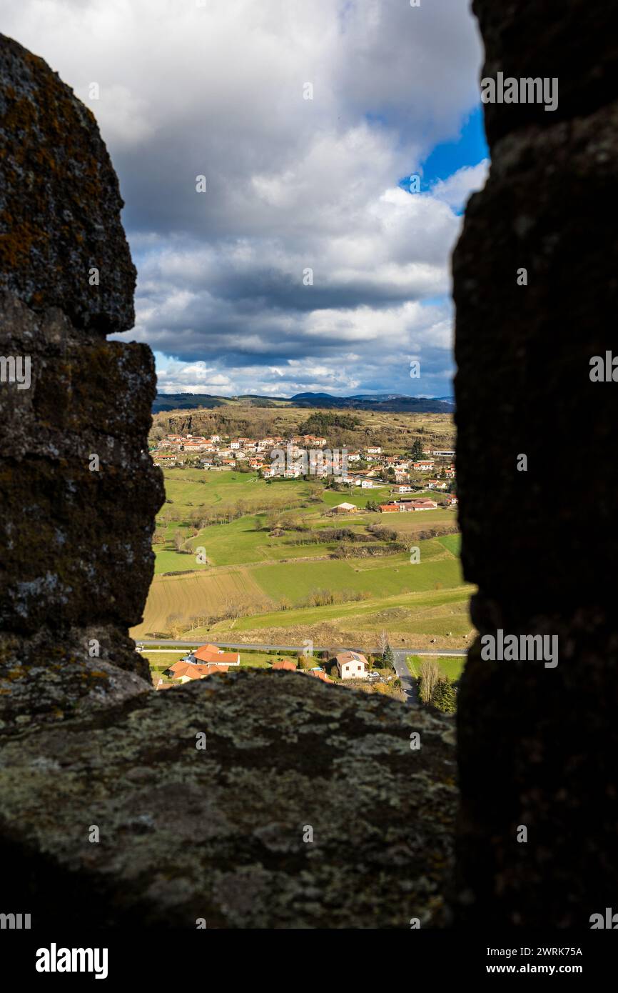 Vista verso il borgo di Tressac, ai piedi di un massiccio di roccia vulcanica, dai bastioni della fortezza di Polignac vicino a Puy-en-Velay Foto Stock