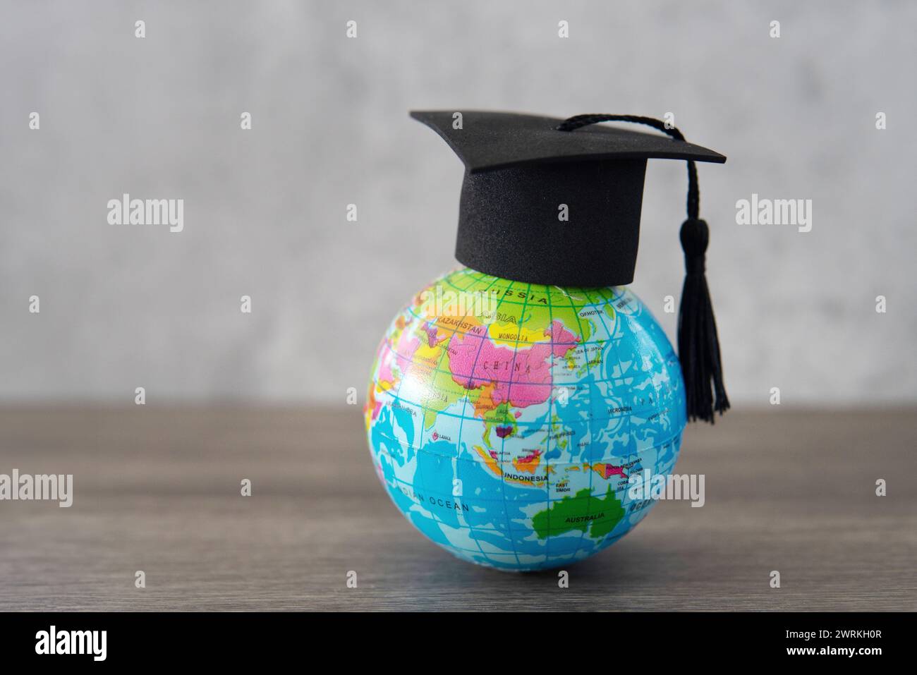 Cappuccio graduato sulla parte superiore del globo con spazio di copia. Studia all'estero. concetto di studenti stranieri. Foto Stock