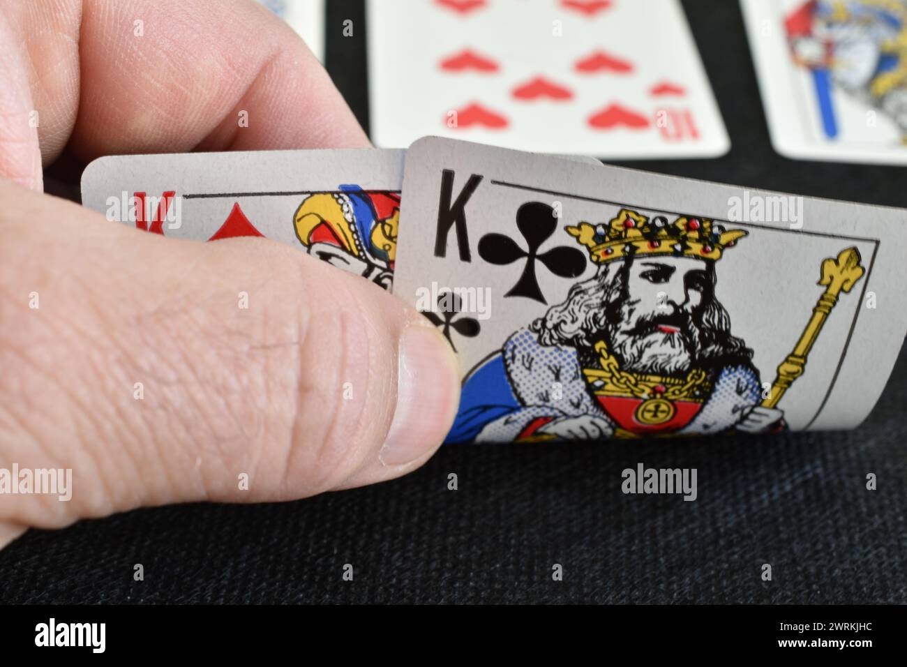 Momento di gioco. Il giocatore guarda le carte. Ha un paio di re. Foto Stock