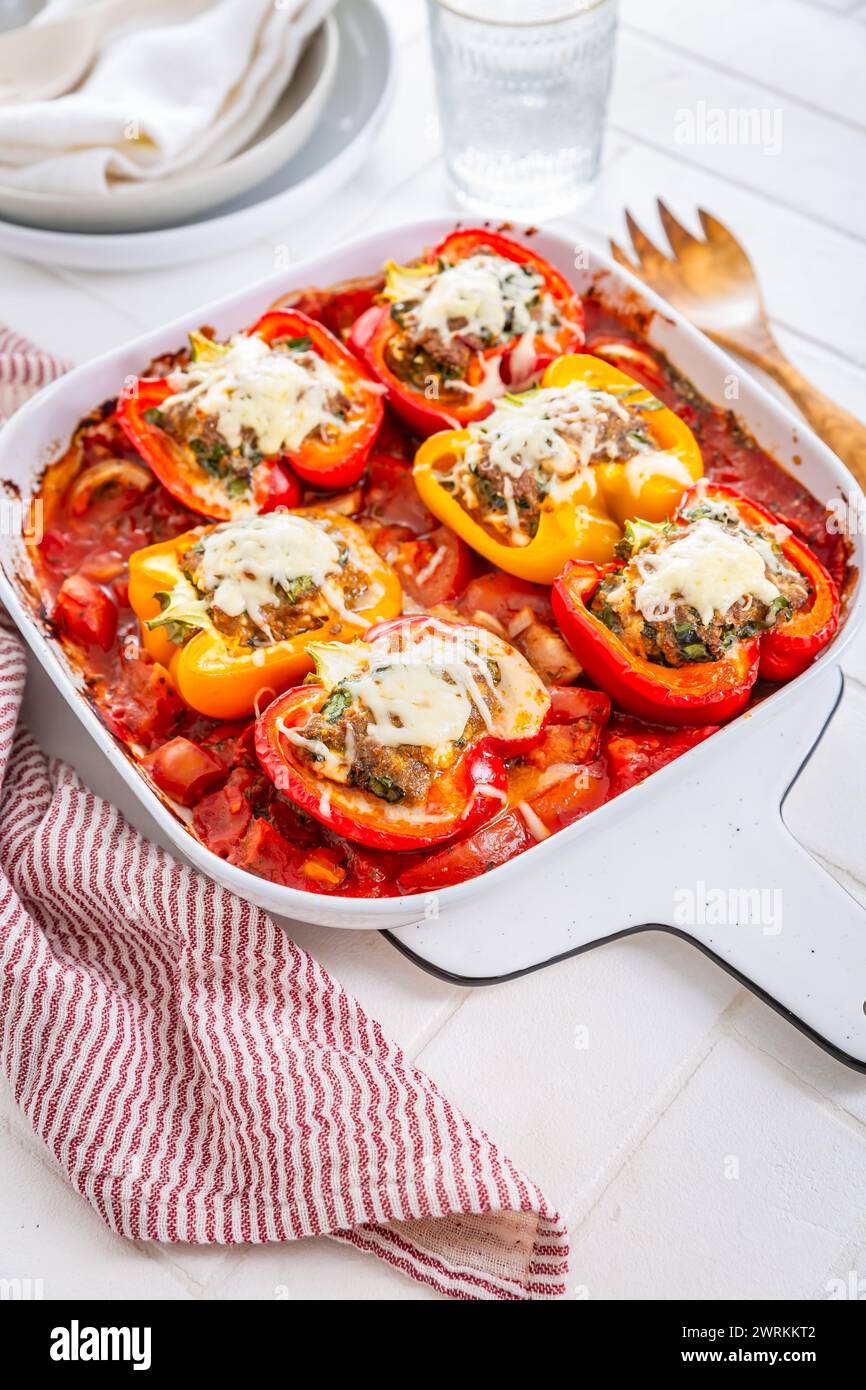 Peperoni ripieni di carne macinata, formaggio feta, ramson e pomodori in casseruola Foto Stock