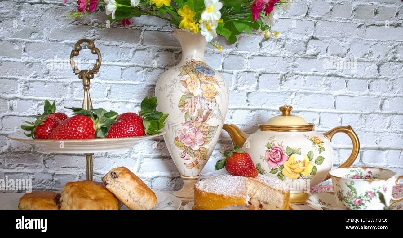 Tè pomeridiano in stile vintage, fragole e focaccine tradizionali con crema Victoria Sponge Foto Stock