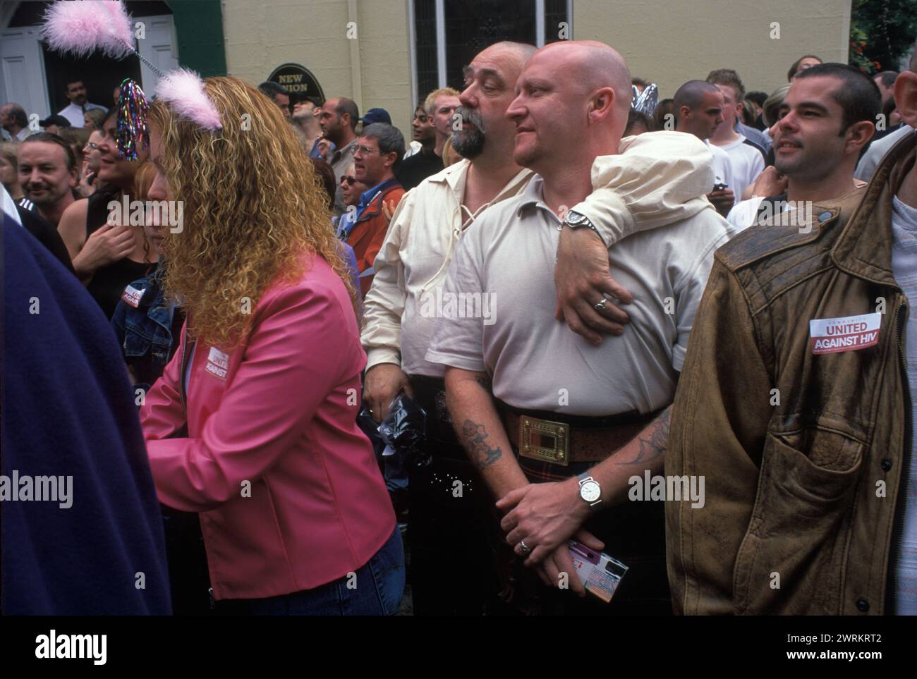 Manchester Pride Festival 1990s Regno Unito. Il festival annuale del Gay Pride. Due "orsi", gli orsi sono pesantemente costruiti, uomini gay stanno tra la folla con le braccia l'uno intorno all'altro. Guarda la sfilata attraverso il cosiddetto Pink Village England 1999, HOMER SYKES Foto Stock