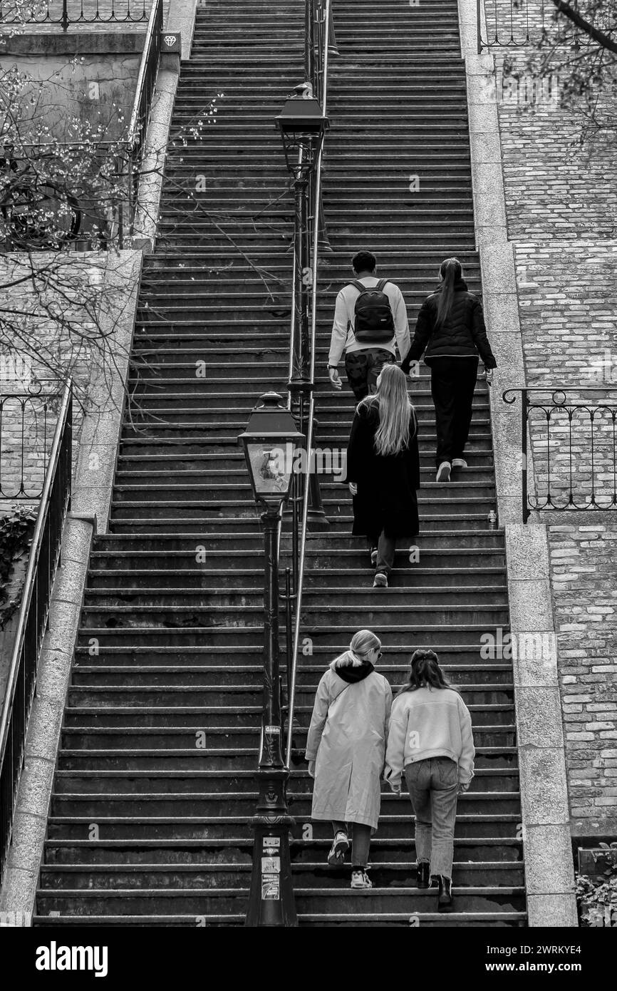 Parigi, Francia - 17 febbraio 2024: Veduta dei turisti che camminano su e giù per le pittoresche scale nell'area di Montmartre a Parigi Francia Foto Stock