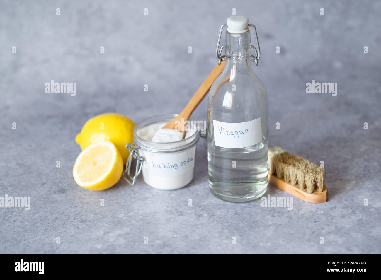 Prodotti per la pulizia ecologici: Aceto bianco, bicarbonato, limone, spazzola. Le alternative di pulizia ecologiche su superfici diverse rimuovono le macchie. Foto Stock