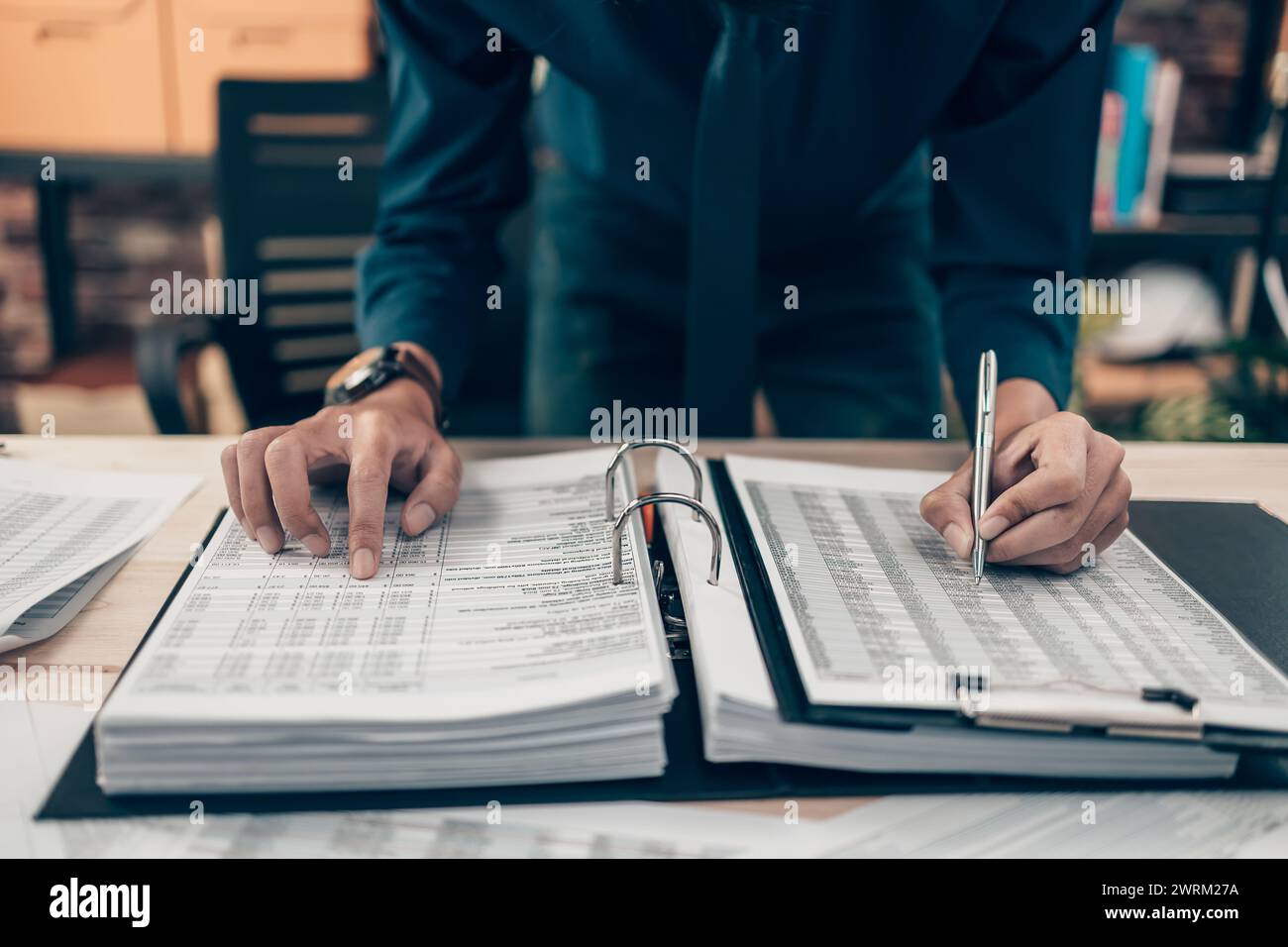 Gli investitori che lavorano in ufficio e puntano le dita per controllare i costi, l'equilibrio, il lavoro e la valuta. Concetto contabile e finanziario. Foto Stock