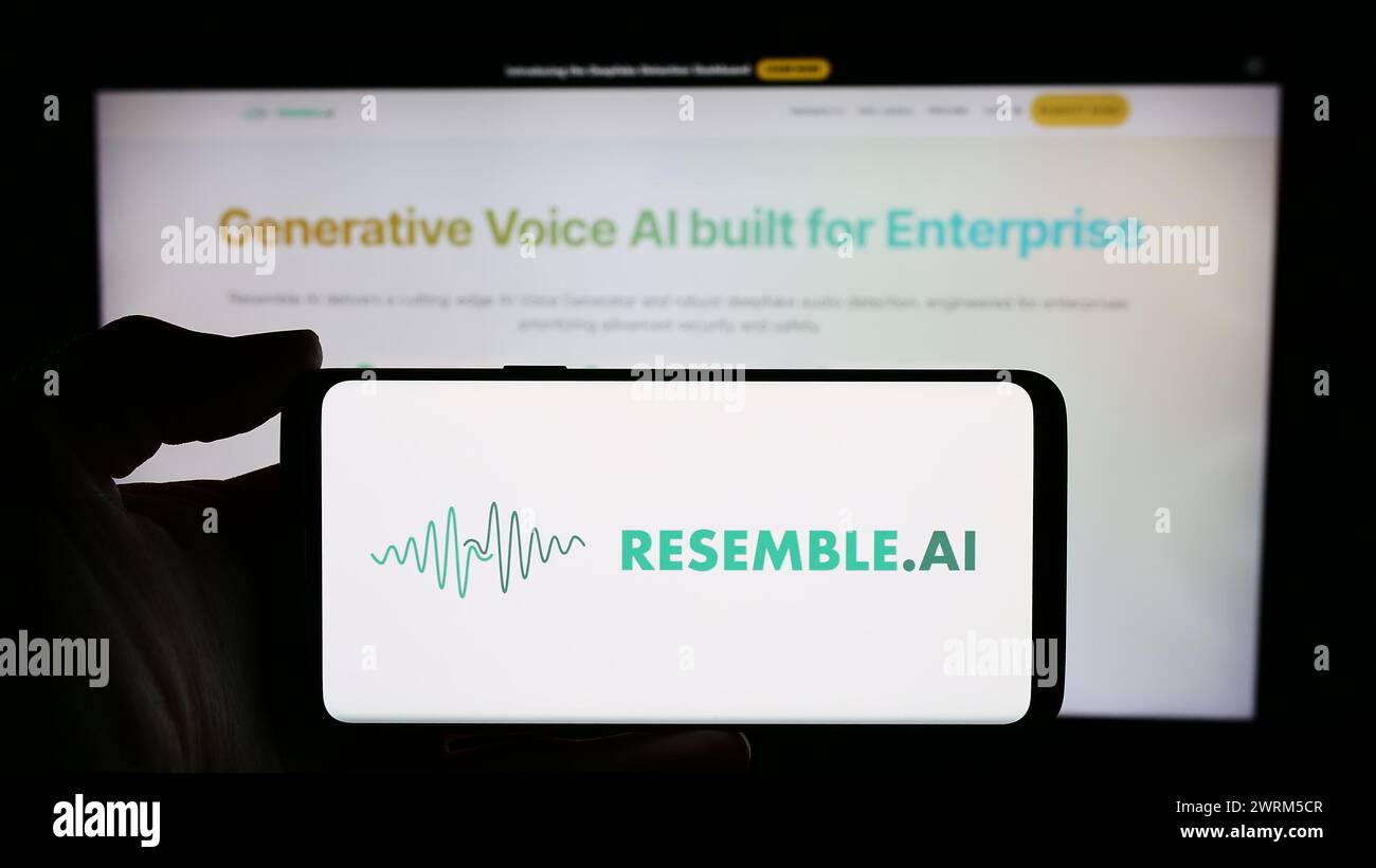 La persona che detiene un cellulare con il logo della società canadese di intelligenza artificiale assomiglia all'IA di fronte alla pagina Web aziendale. Mettere a fuoco il display del telefono. Foto Stock