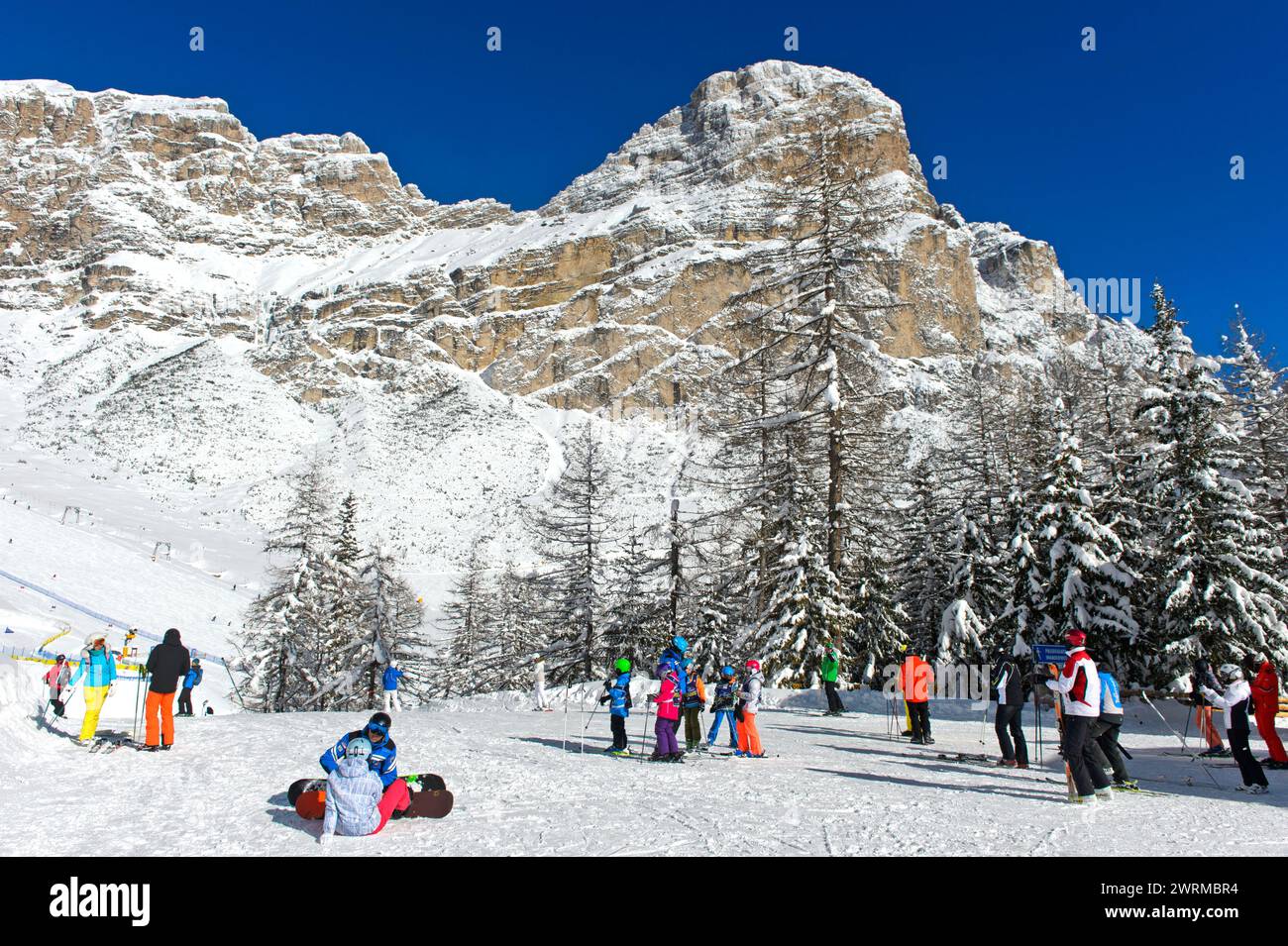 Sciatori sul col Pradat di fronte alla vetta innevata del Sassongher, Colfosco, comprensorio sciistico dell'alta Badia, Dolomiti, alto Adige, Italia Foto Stock