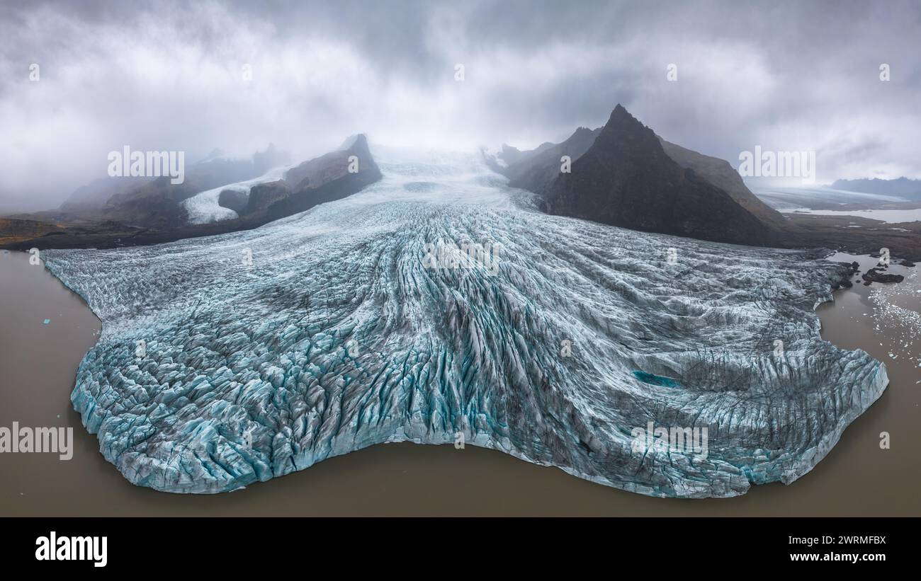 Un'eterea vista aerea del ghiacciaio Vatnajokull avvolto dalla nebbia, che mostra le intricate texture e la dura bellezza delle meraviglie naturali dell'Islanda Foto Stock