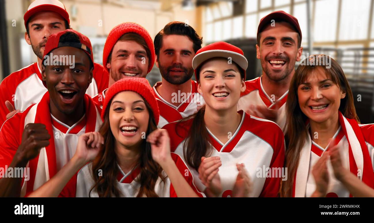 Vista frontale di un gruppo di appassionati di sport che indossano maglie rosse e bianche vivaci applausi Foto Stock