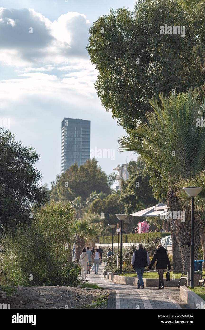 Limassol, Cipro - 14 gennaio 2024: Persone che camminano in un parco sul mare nella zona di Agios Tychon a Limassol Foto Stock