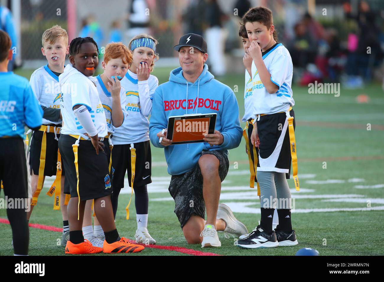 Un allenatore si accosta con alcuni giocatori di calcio giovanili che hanno partecipato alla Snoop & House Flag Football League presso il Campus El Segundo Athletic Fields, venerdì 8 marzo 2024, a El Segundo. (Kevin Terrell/immagine dello sport) Foto Stock