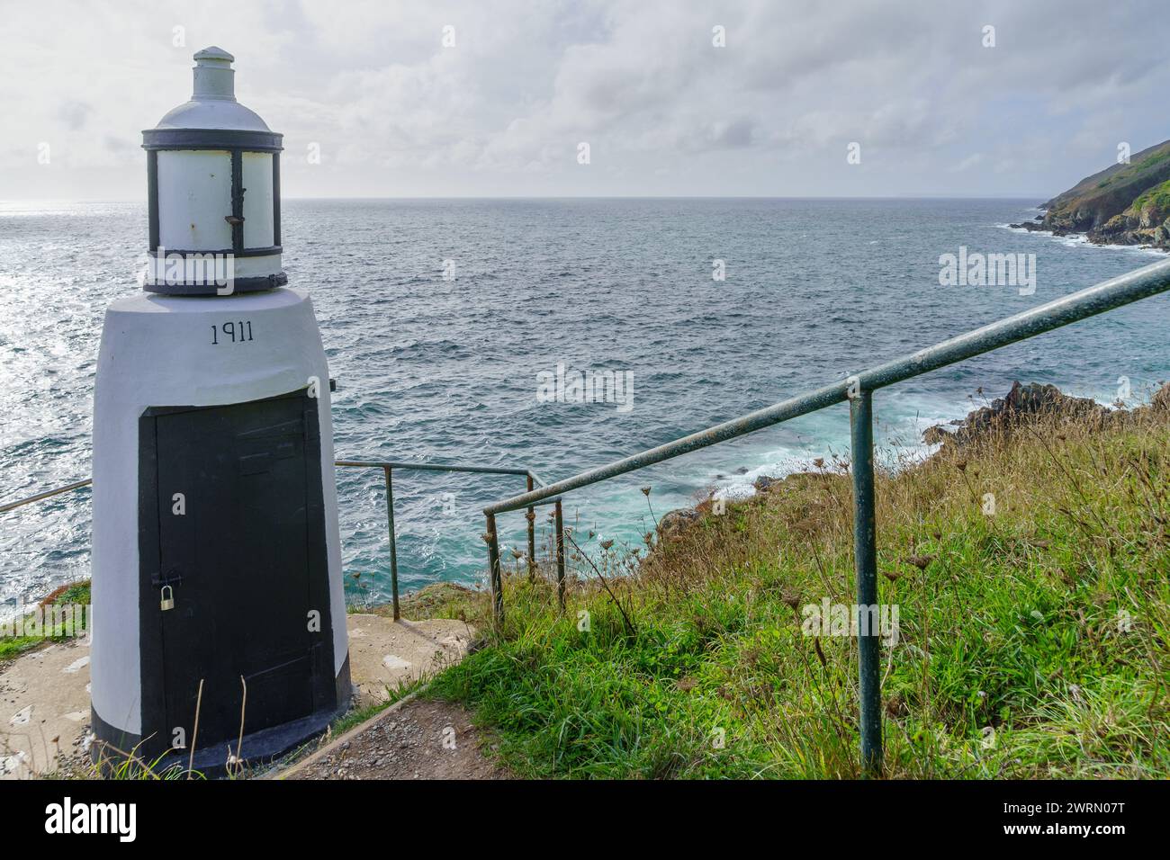 Vista del faro di Spy House Point (numero che segna l'anno di costruzione: 1911), nel villaggio di pescatori Polperro, Cornovaglia, Inghilterra, Regno Unito Foto Stock