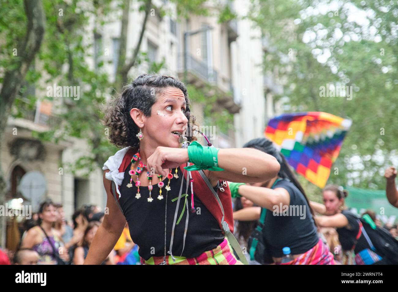 Buenos Aires, Argentina; 8 marzo 2024: Donne che indossano tessuti tradizionali colorati e sventolano la danza wiphala mentre marciano durante gli internazionali Foto Stock