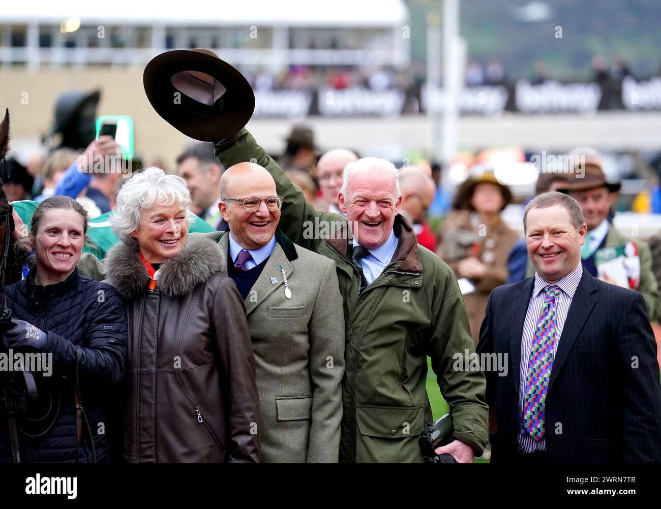 Il co-proprietario Simon Munir, l'allenatore Willie Mullins e sua moglie Jackie Mullins posano per una foto mentre celebrano dopo che Jasmin De Vaux ha vinto il Weatherbys Champion Bumper il secondo giorno del Cheltenham Festival 2024 all'ippodromo di Cheltenham. Willie Mullins ha raggiunto il magico punteggio di 100 vincitori al Cheltenham Festival mentre il Patrick Mullins-cavalcato Jasmin De Vaux gli ha dato una tredicesima vittoria nel Weatherbys Champion Bumper. Data foto: Mercoledì 13 marzo 2024. Foto Stock