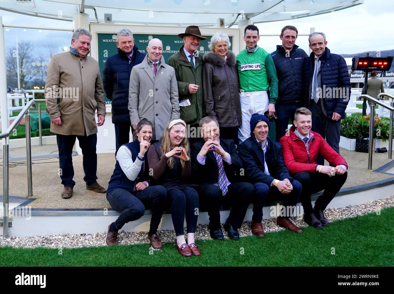 L'allenatore Willie Mullins, la moglie Jackie Mullins, il fantino Patrick Mullins, Ruby Walsh e i loro colleghi si mettono in posa per una foto mentre celebrano dopo che Jasmin De Vaux ha vinto il Weatherbys Champion Bumper il secondo giorno del Cheltenham Festival 2024 all'ippodromo di Cheltenham. Willie Mullins ha raggiunto il magico punteggio di 100 vincitori al Cheltenham Festival mentre il Patrick Mullins-cavalcato Jasmin De Vaux gli ha dato una tredicesima vittoria nel Weatherbys Champion Bumper. Data foto: Mercoledì 13 marzo 2024. Foto Stock