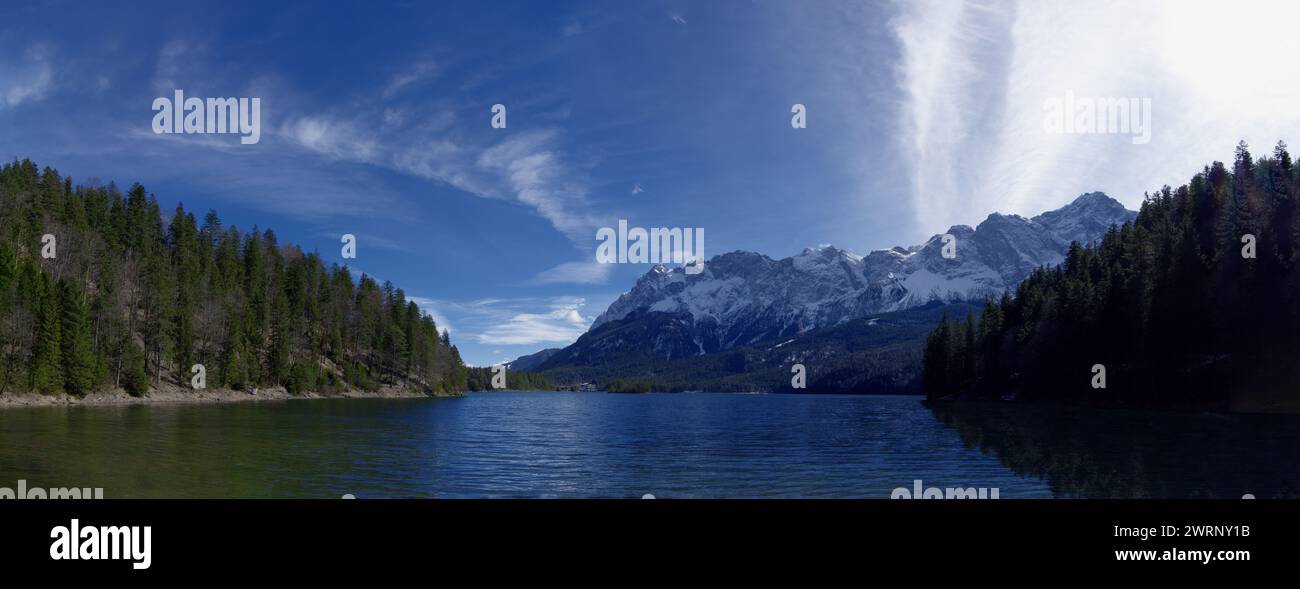 Panorama del lago, della foresta e delle montagne alte con la neve Foto Stock