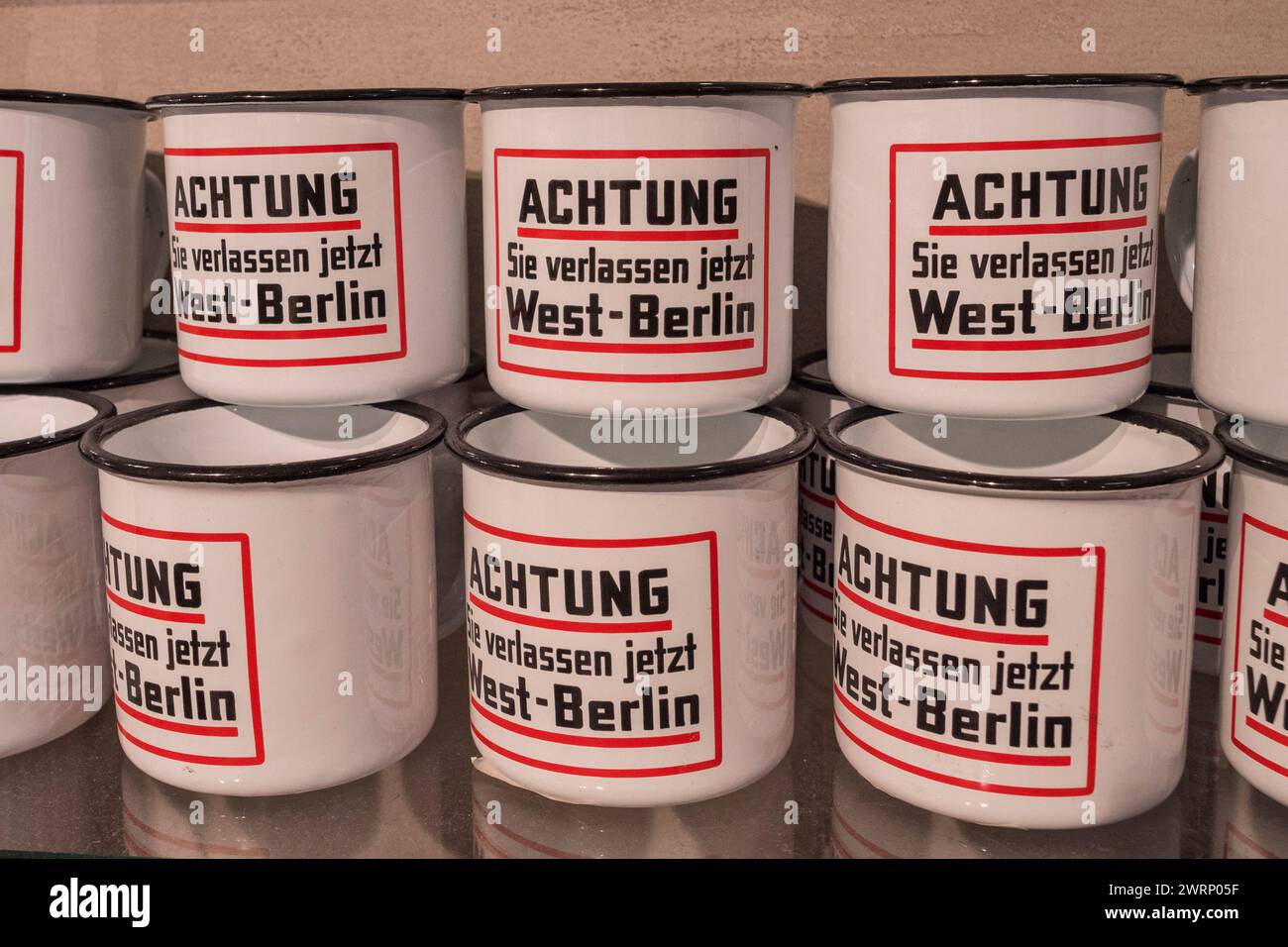 Tazze souvenir "Achtung Sie verlassen jetzt Berlino Ovest" nel negozio del Checkpoint Charlie Museum di Berlino, Germania. Foto Stock