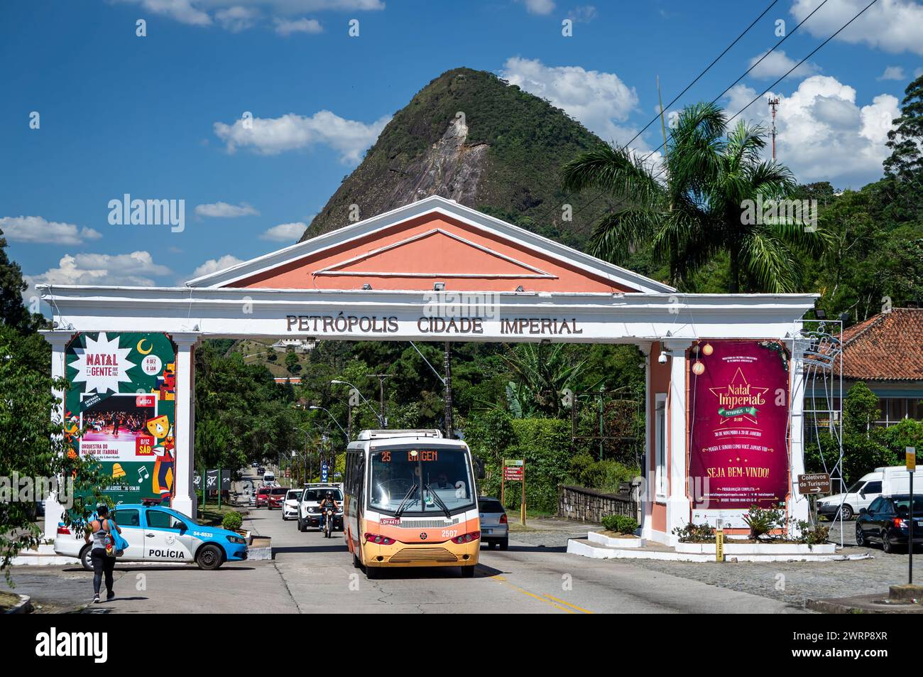 La porta della città imperiale di Petropolis su Ayrton Senna avenue mentre il traffico passa sotto di essa sotto sotto il cielo azzurro nuvoloso del pomeriggio estivo. Foto Stock