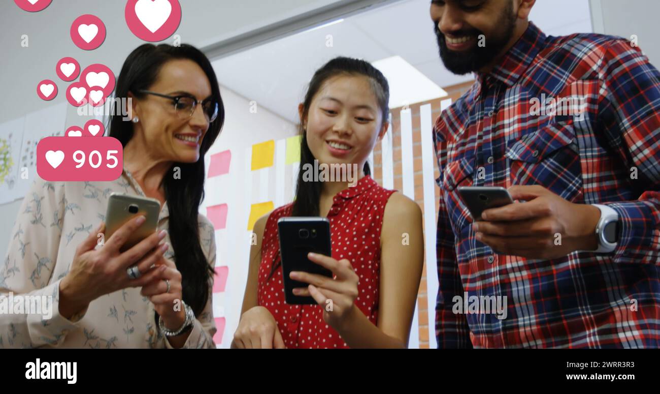 Le icone dei social media digitali passano il mouse sopra il sorridente trio dell'ufficio sugli smartphone. Foto Stock