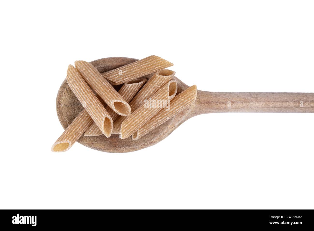 una piccola pila di pasta integrale su un mestolo di legno Foto Stock