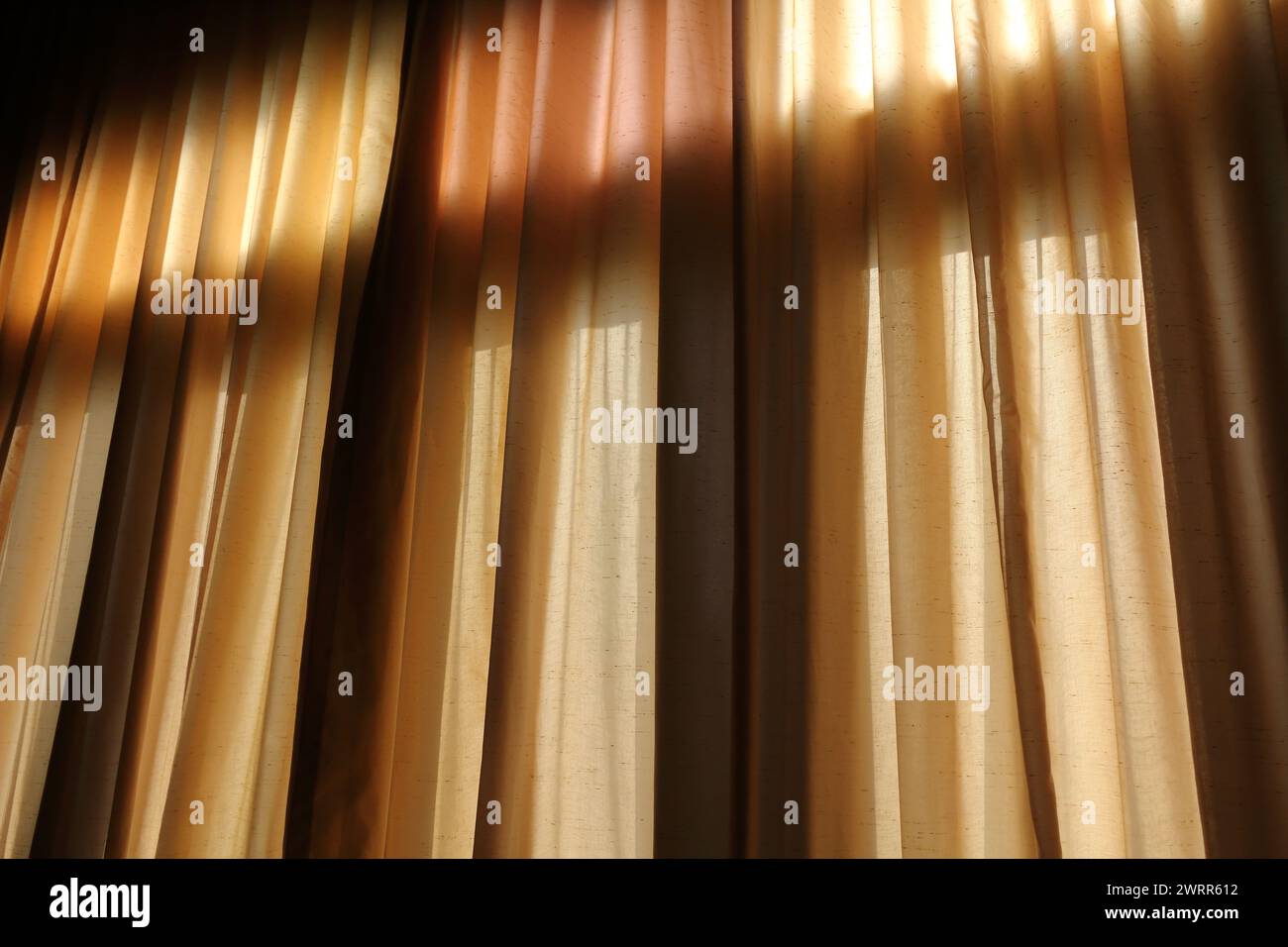 Luce attraverso la tenda nella stanza buia Foto Stock