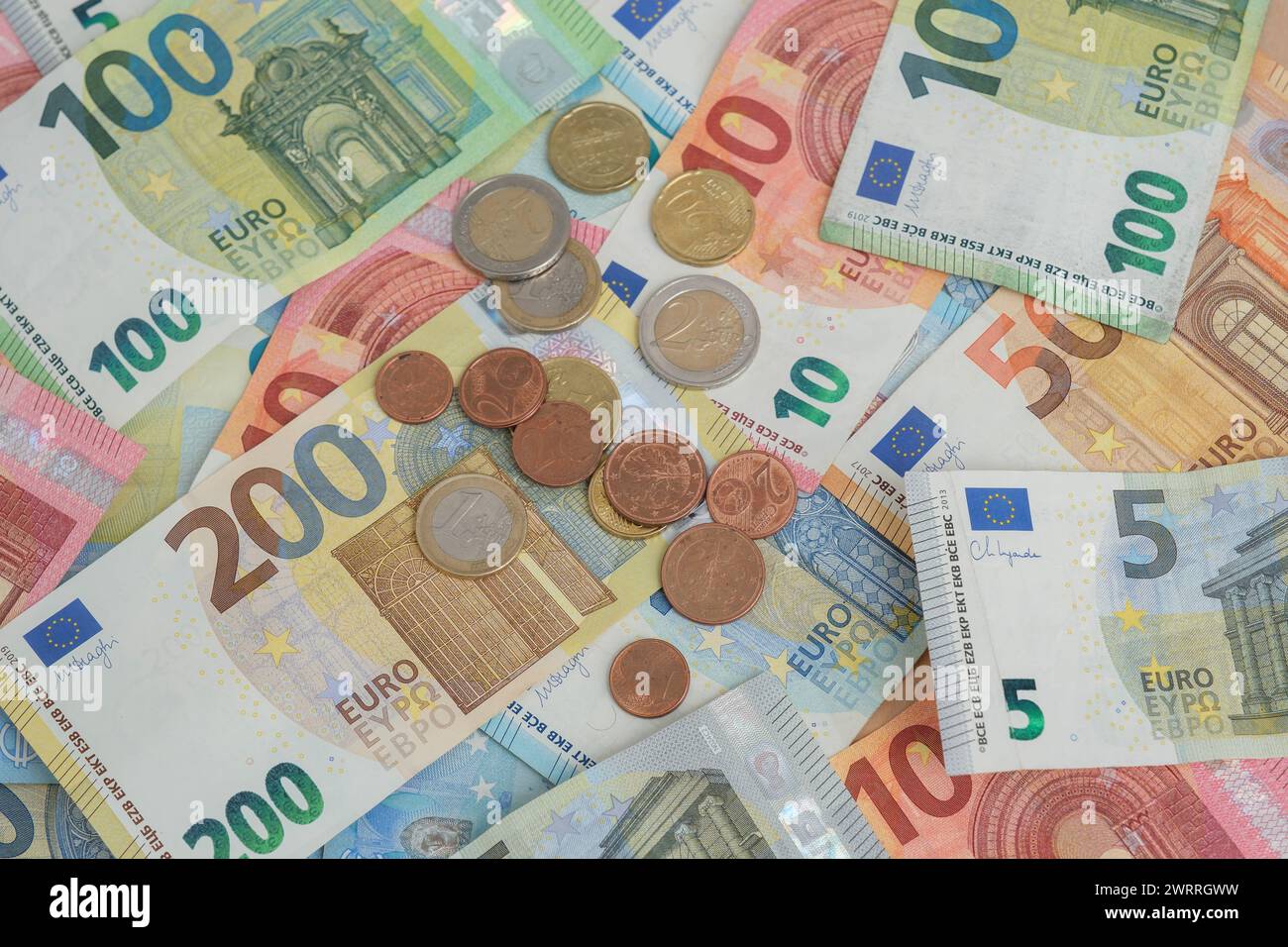 Accumulo di banconote e monete in euro Foto Stock