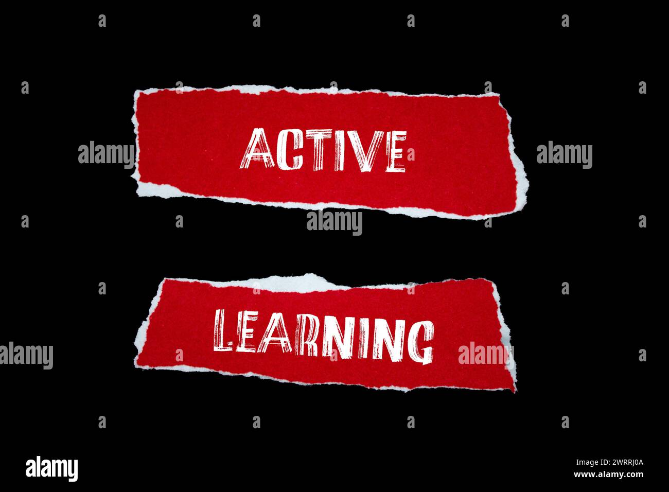 Parole di apprendimento attive scritte su pezzi di carta strappati di colore rosso con sfondo nero. Simbolo concettuale. Copia spazio. Foto Stock