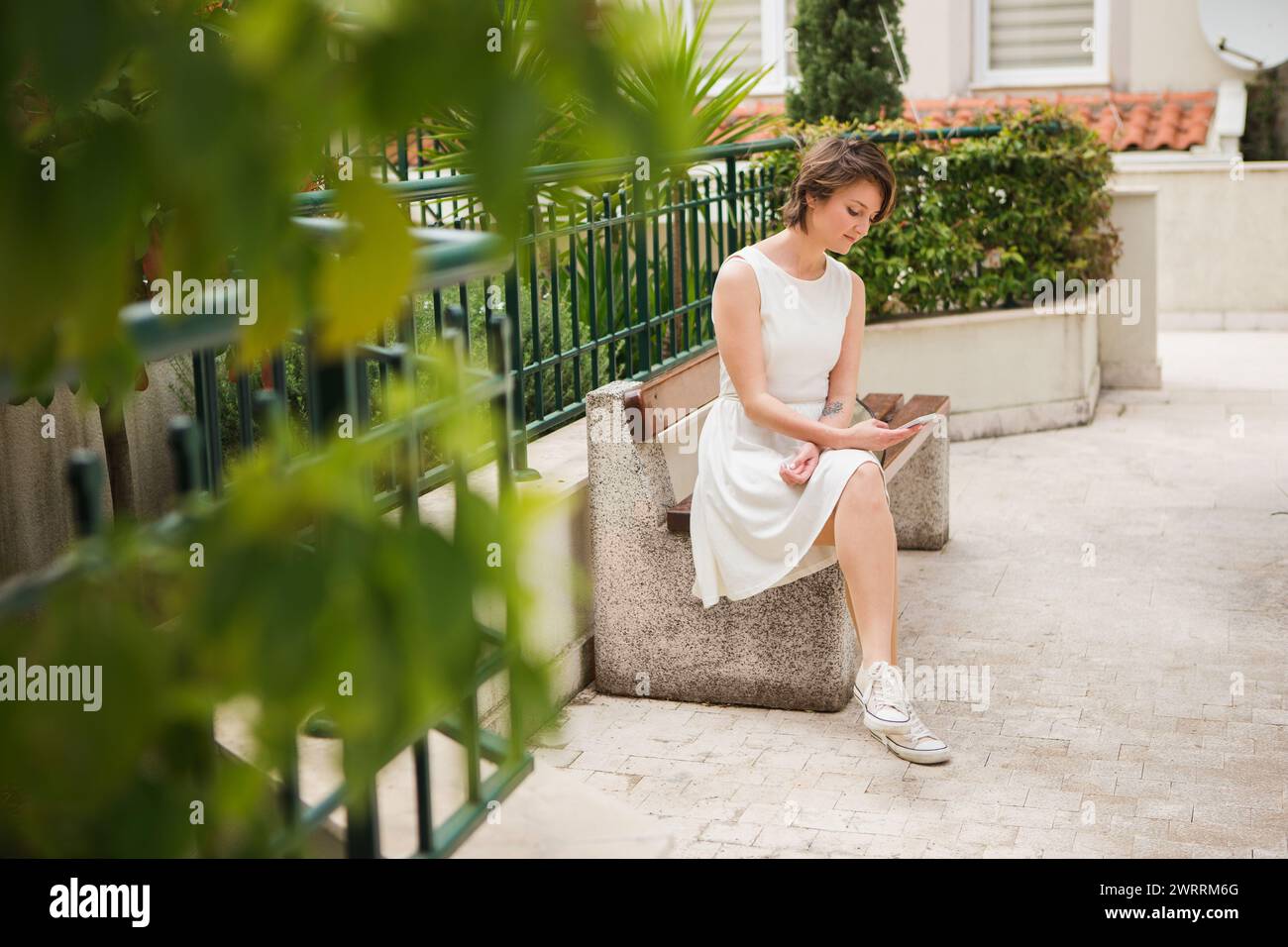Una donna tiene uno smartphone tra le mani. Donna turistica sulla strada della città costiera. Foto Stock