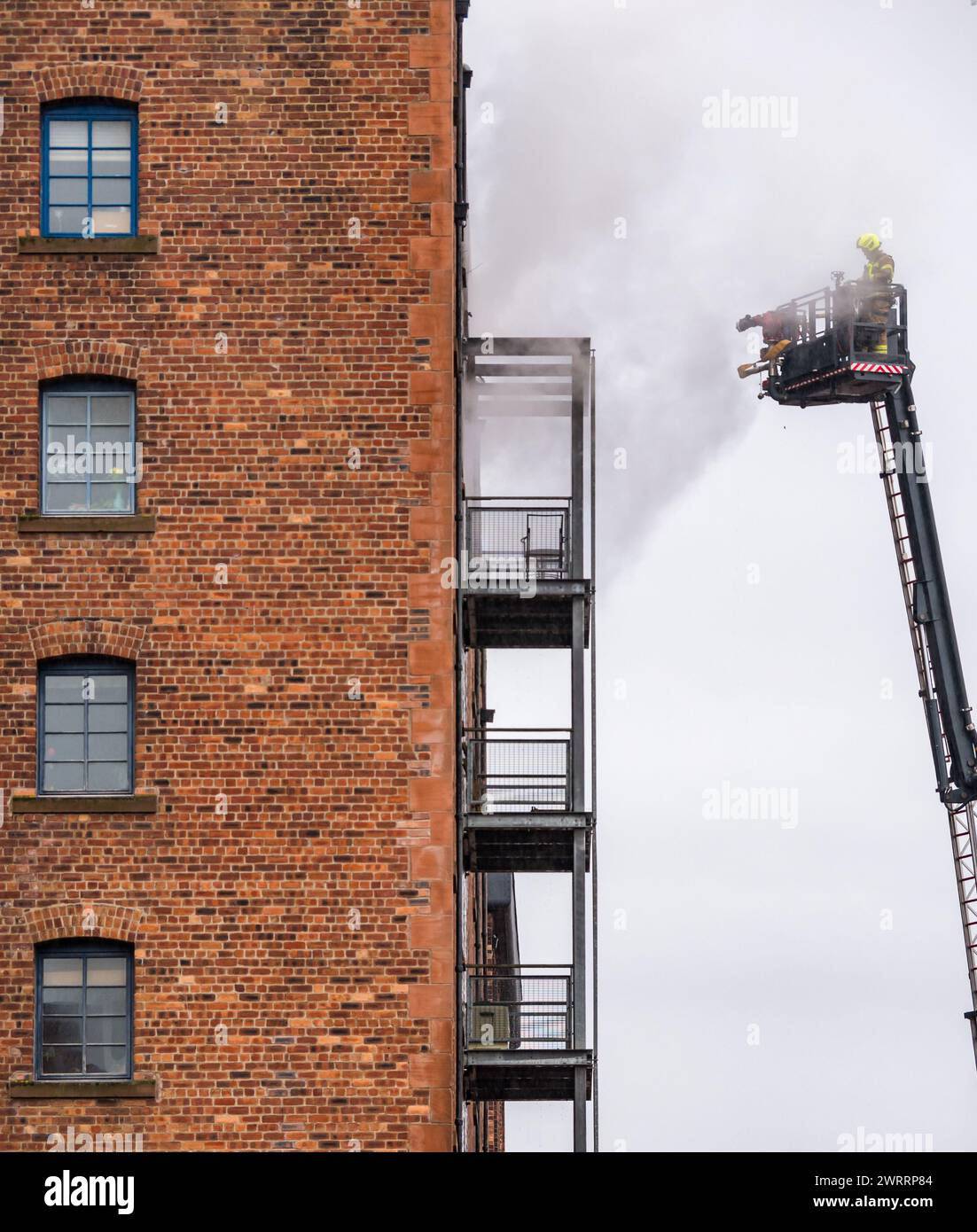 Edimburgo, Scozia, Regno Unito, 14 marzo 2024. Incendio al blocco di appartamenti a Bonnington: Un grande incendio è scoppiato alle 4 di stamattina. I servizi di emergenza sono presenti e il fumo è visto spargere fuori da un balcone piatto nel magazzino obbligazioni convertito. Crediti: Sally Anderson/Alamy Live News Foto Stock