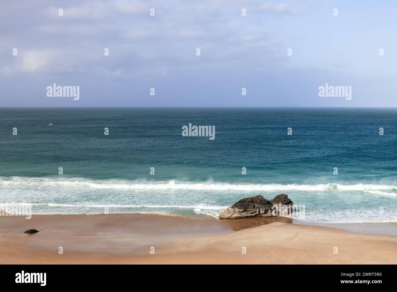 Una tranquilla vista di Durness Beach, che mostra le tranquille acque blu dell'Atlantico che incontrano le sabbie dorate. Si erge una formazione rocciosa solitaria Foto Stock