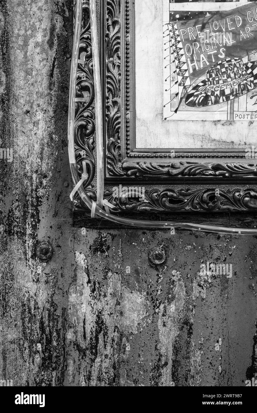 Cornice per immagini antica adagiata su un muro arrugginito di un vecchio capannone in metallo ondulato a Bridport. Astratto, sfondo di texture. Grunge. Arte. Foto Stock