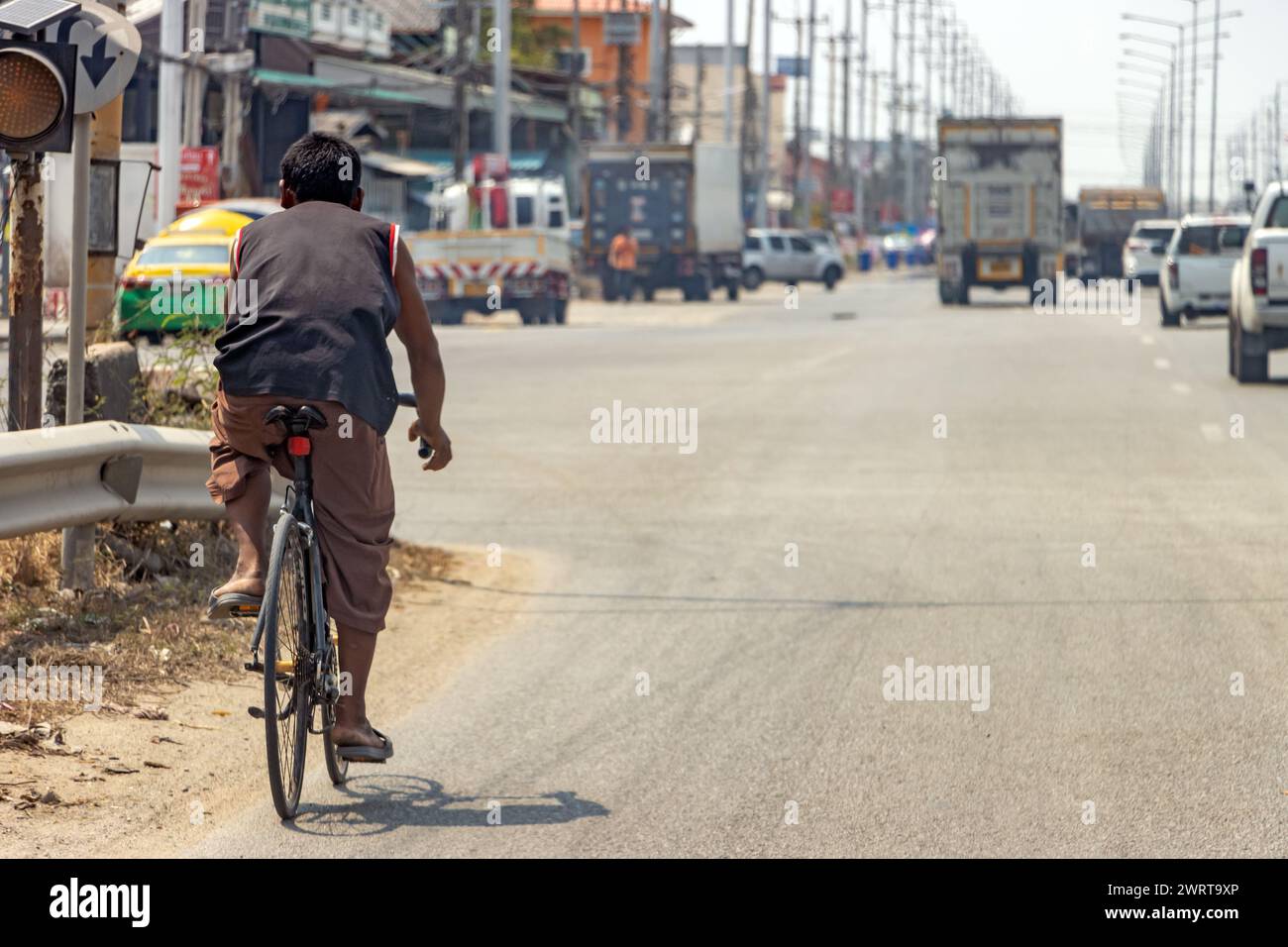 Un uomo guida una bici da strada su un'autostrada nel centro della città, Bangkok, Thailandia Foto Stock