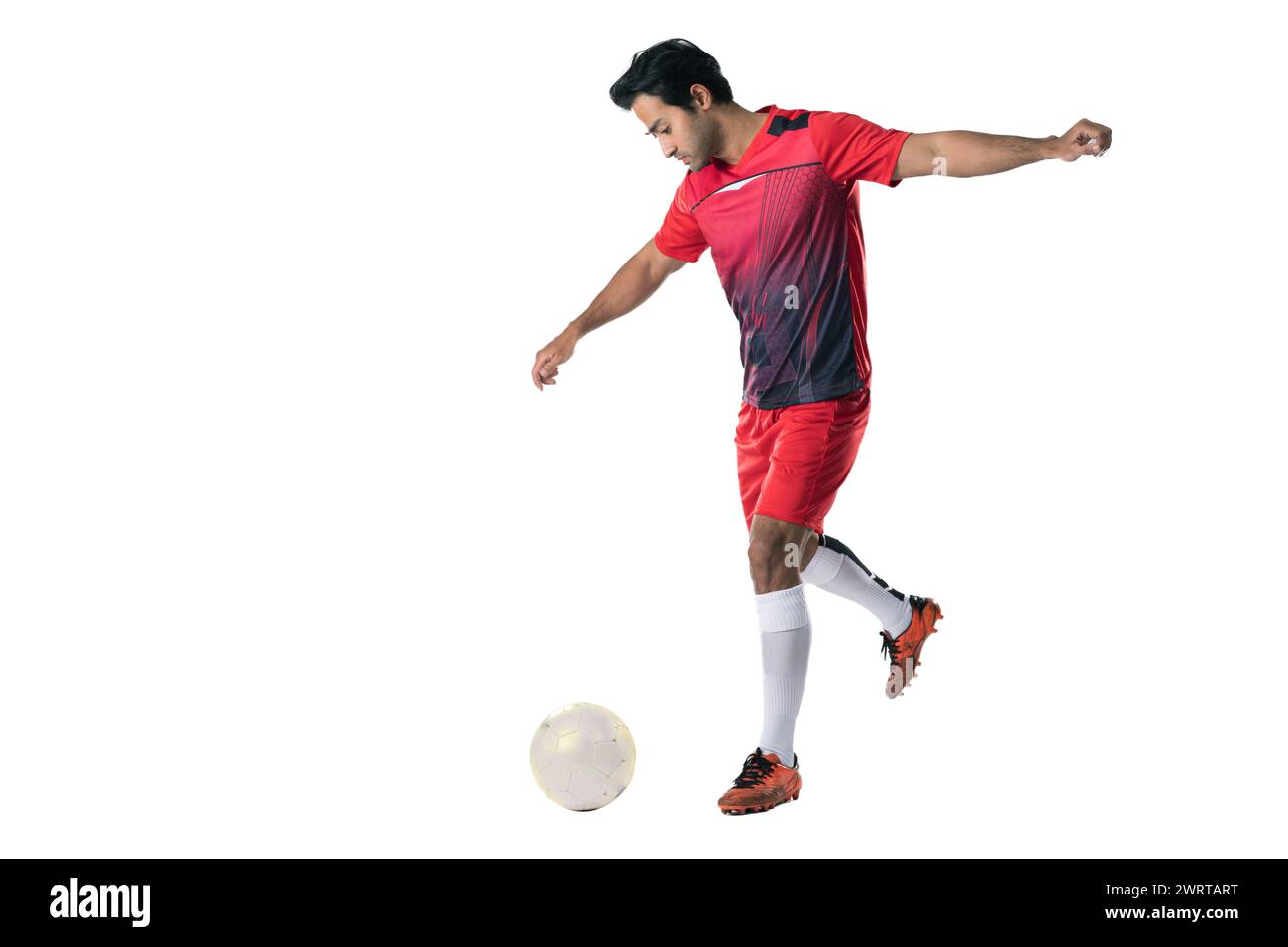 Giocatore di calcio professionista in uniforme da allenamento rossa posa su uno sfondo bianco concetto di calcio stile di vita attivo e sano Foto Stock Giocatore di calcio professionista in uniforme da allenamento rossa posa su uno sfondo bianco concetto di calcio stile di vita attivo e sano Foto Stock