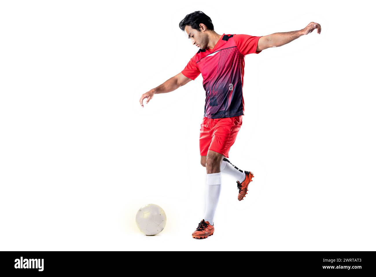 Giocatore di calcio professionista in uniforme da allenamento rossa posa su uno sfondo bianco concetto di calcio stile di vita attivo e sano Foto Stock Giocatore di calcio professionista in uniforme da allenamento rossa posa su uno sfondo bianco concetto di calcio stile di vita attivo e sano Foto Stock