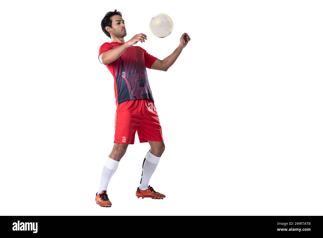 Giocatore di calcio professionista in uniforme da allenamento rossa posa su uno sfondo bianco concetto di calcio stile di vita attivo e sano Foto Stock Giocatore di calcio professionista in uniforme da allenamento rossa posa su uno sfondo bianco concetto di calcio stile di vita attivo e sano Foto Stock