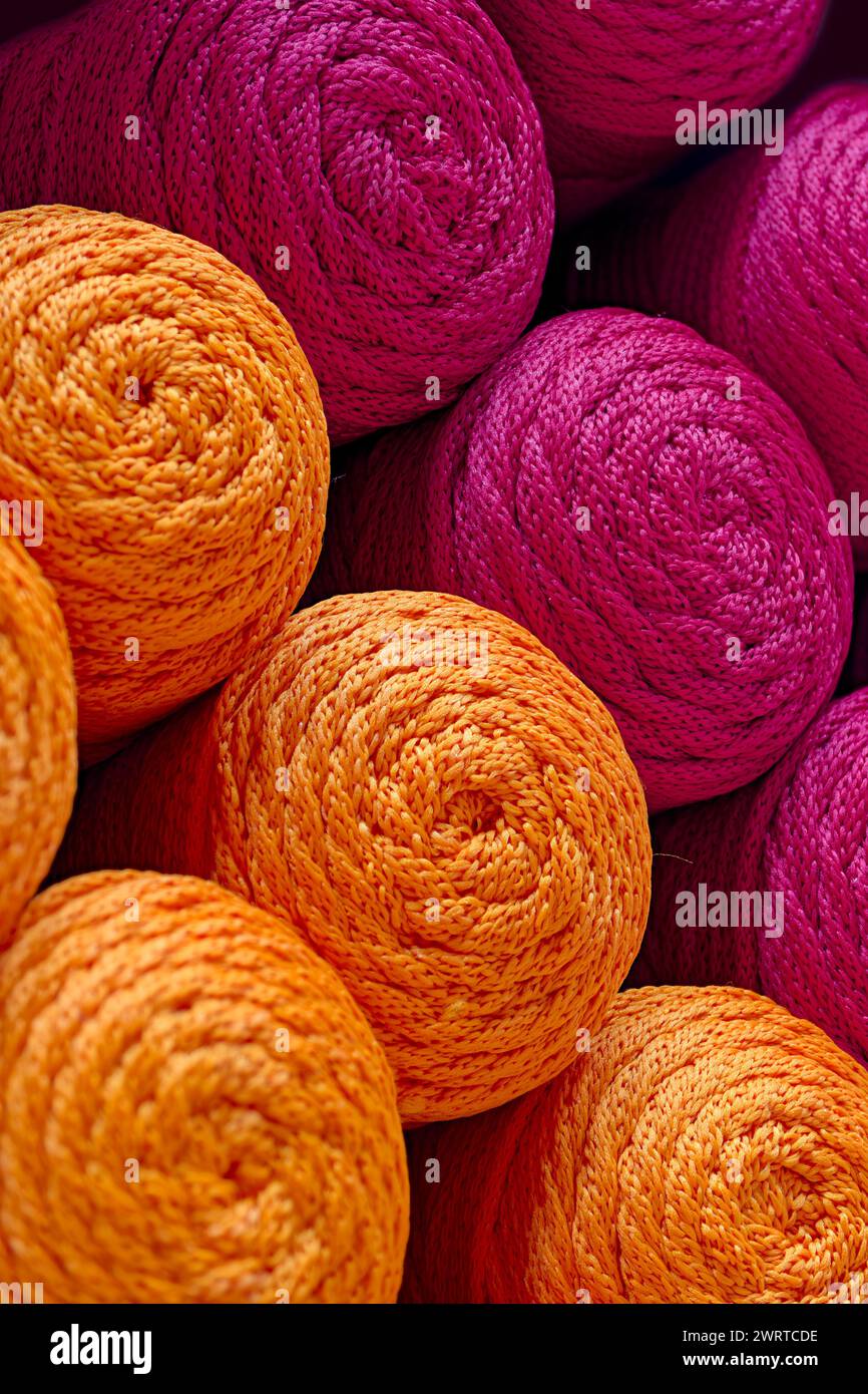 Palline multiple di fili arancioni e rossi, sfondo in tessuto astratto Foto Stock
