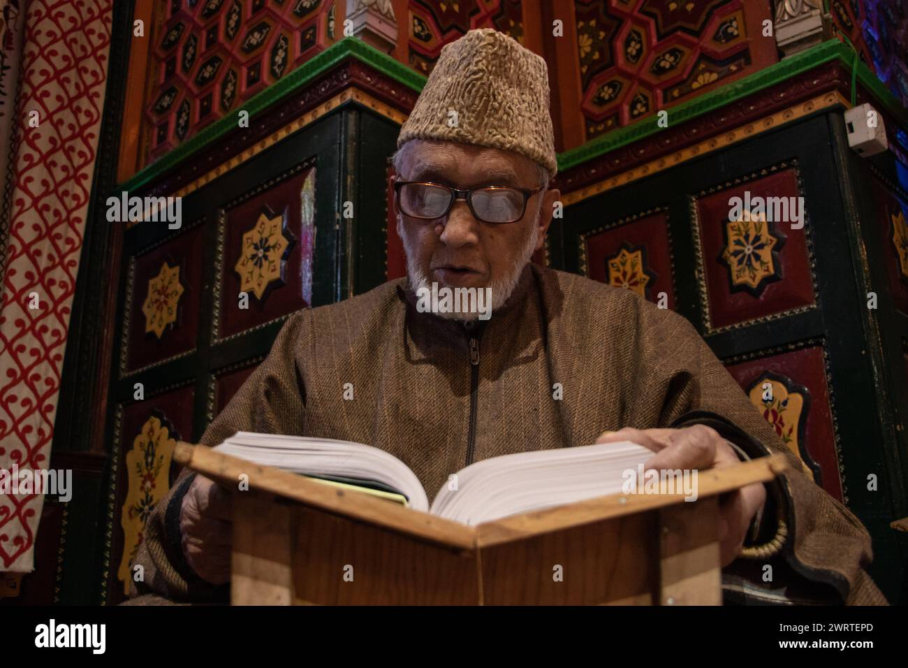 Srinagar, Kashmir, India. 14 marzo 2024. Un musulmano kashmiri legge il Corano mentre prega all'interno di un santuario il terzo giorno del mese islamico del Ramadan a Srinagar. Il Ramadan è il nono mese del calendario islamico e ha un significato speciale nell'Islam. I musulmani credono che durante questo mese, i primi versi del Corano, il libro sacro dell'Islam, siano stati rivelati al profeta Maometto. (Credit Image: © Adil Abbas/ZUMA Press Wire) SOLO PER USO EDITORIALE! Non per USO commerciale! Foto Stock