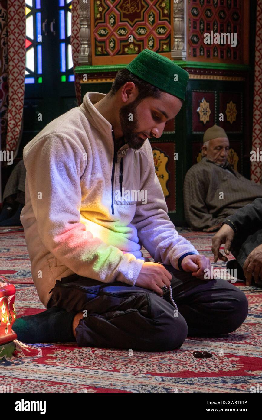 Srinagar, Kashmir, India. 14 marzo 2024. Un musulmano del Kashmir sta pregando all'interno di un santuario il terzo giorno del mese islamico del Ramadan a Srinagar. Il Ramadan è il nono mese del calendario islamico e ha un significato speciale nell'Islam. I musulmani credono che durante questo mese, i primi versi del Corano, il libro sacro dell'Islam, siano stati rivelati al profeta Maometto. (Credit Image: © Adil Abbas/ZUMA Press Wire) SOLO PER USO EDITORIALE! Non per USO commerciale! Foto Stock