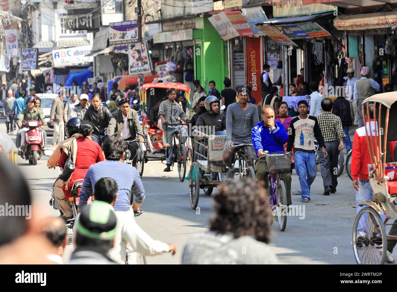 I risciò in bicicletta e i pedoni si muovono attraverso l'atmosfera vivace della città, Bhairahawa, Nepal Foto Stock