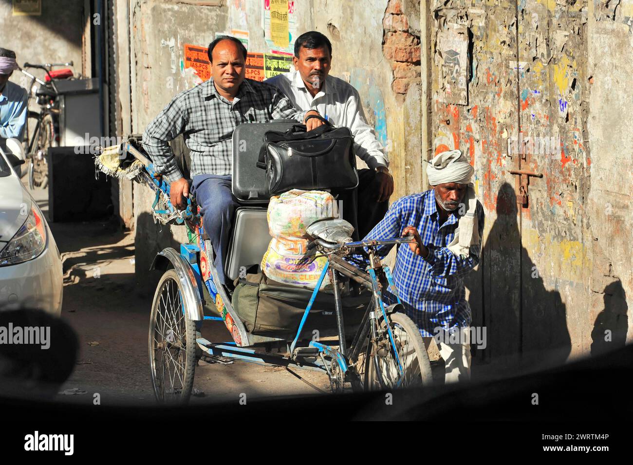 Due uomini in risciò su una strada cittadina, un'altra persona appoggiata accanto a loro, confine India-Nepal, Gorakhpur, Bhairahawa, India, Nepal Foto Stock