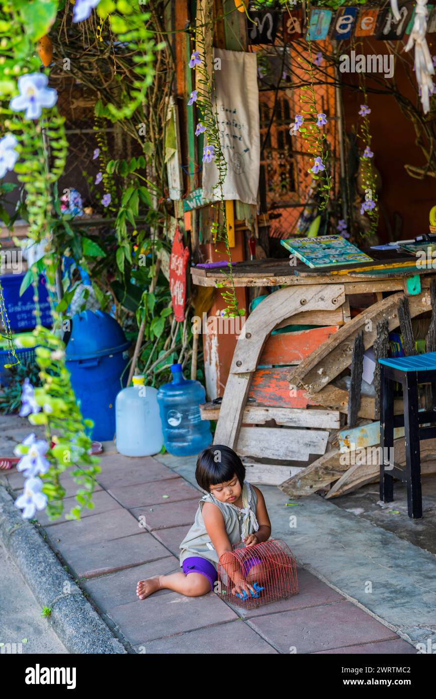 Bambino che gioca in una scena di strada nella città vecchia di Ko Lanta, ramshackle, città, urbano, dal vivo, living, asian, street, exotic, tourism, viaggio, lungo Foto Stock