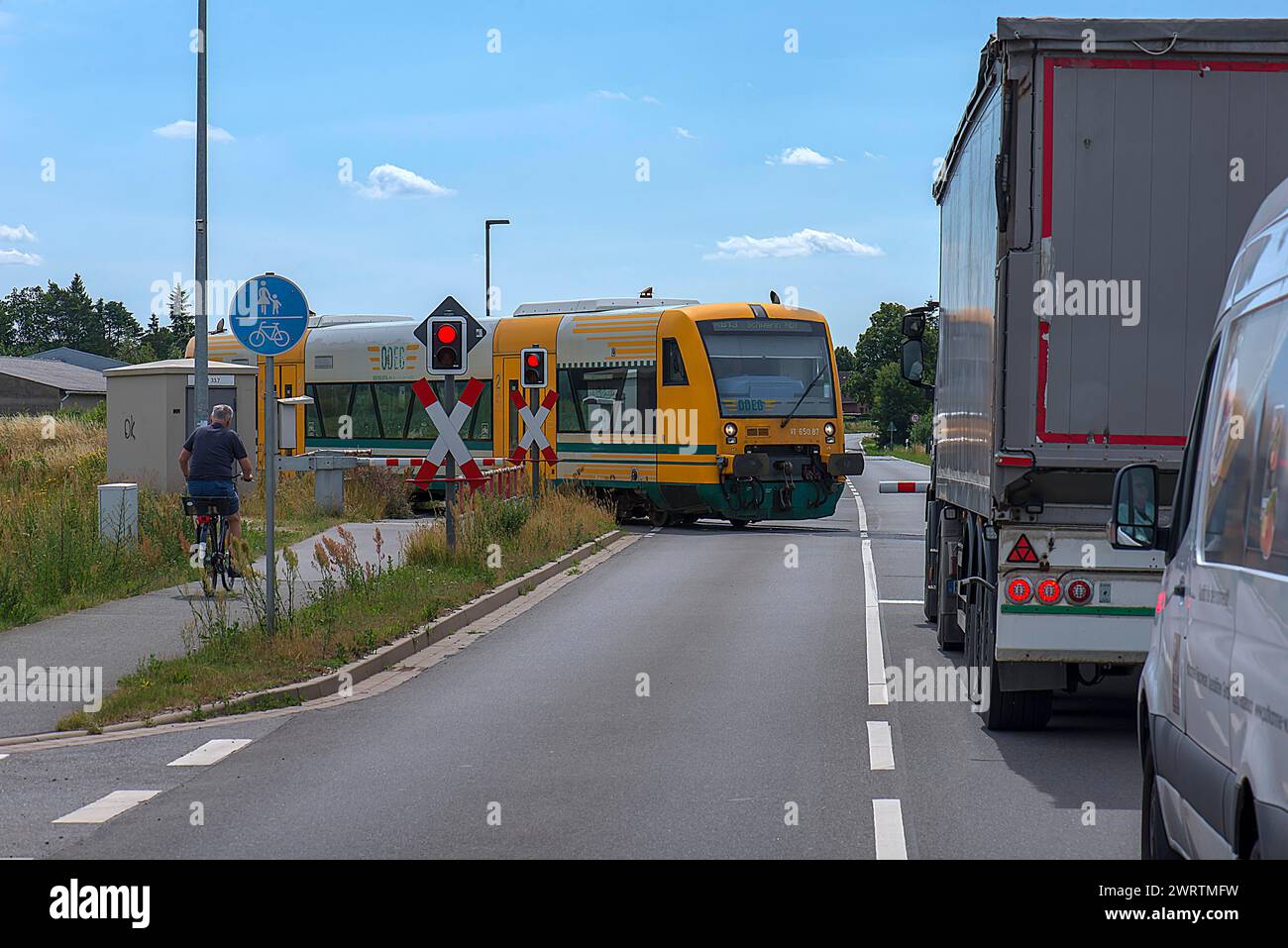 Ferrovia suburbana che attraversa il passaggio a livello recintato, Rehna, Meclemburgo-Pomerania occidentale, Germania Foto Stock