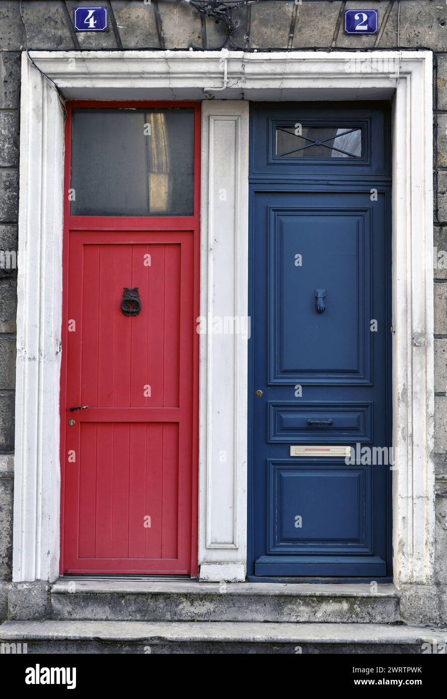 Una porta rossa e una porta blu l'una accanto all'altra Foto Stock