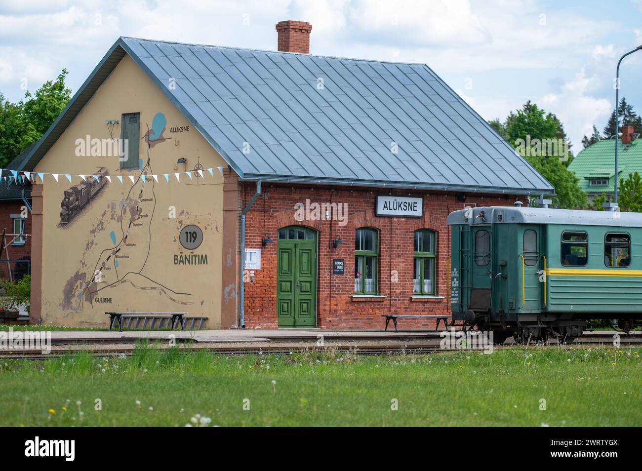 Aluksne, Lettonia - 24 maggio. 2023: Stazione ferroviaria di Aluksne con treno a scartamento ridotto di fronte. Foto Stock