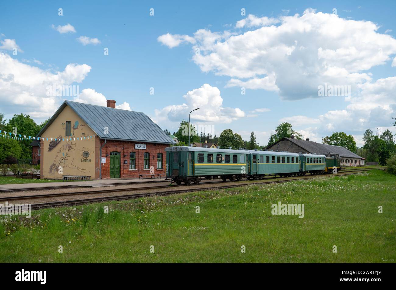 Aluksne, Lettonia - 24 maggio. 2023: Stazione ferroviaria di Aluksne con treno a scartamento ridotto di fronte. Foto Stock
