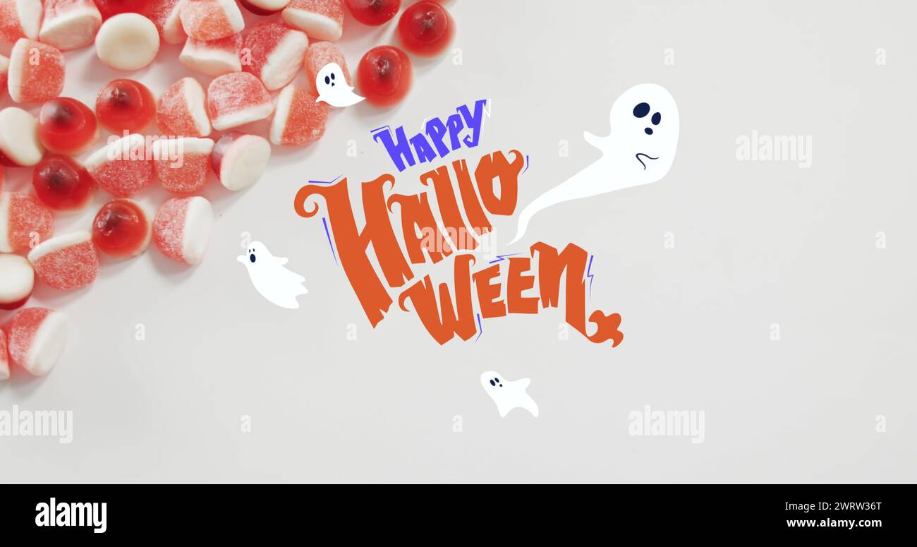 Banner di testo halloween felice e icone fantasmi contro il primo piano di cornici caramelle sulla superficie bianca Foto Stock